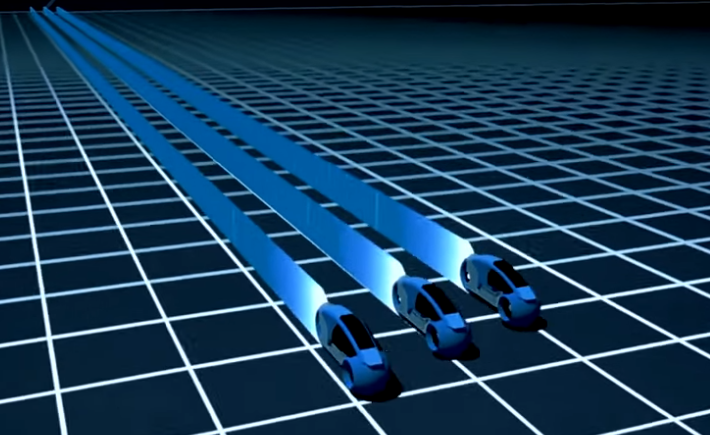 Three blue lightcycles speed through a black plane covered with a white grid. Lightcycles are closed-cockpit motorcycles that can create solid walls of light in their trace.